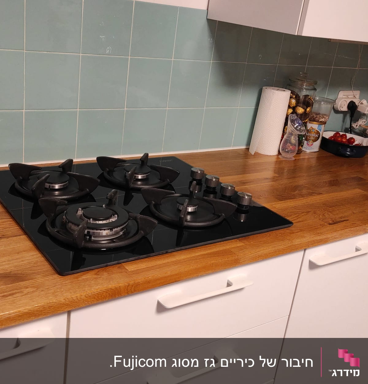 כיריים גז שחורות עם ארבעה מבערים במטבח